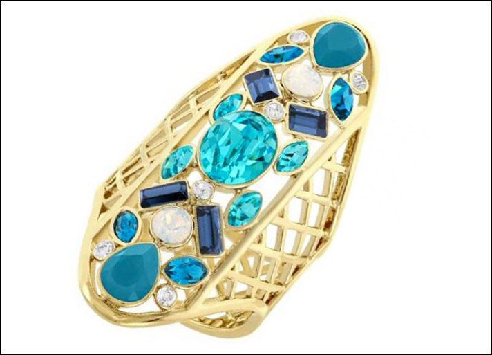 Cyan, anello in metallo Pvd oro traforato e in mezzo cristalli di tagli diversi con nuance dall'azzurro piscina a blu mare.