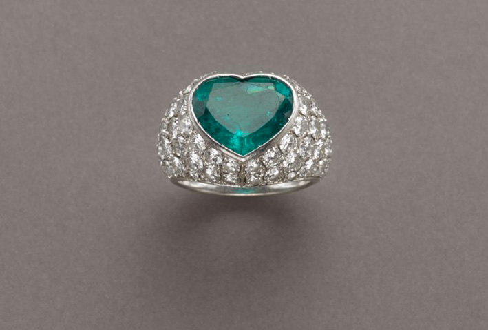 Anello in oro bianco bombato a forma di cuore con pavé di  diamanti taglio a brillante per ct.5,70 circa ed al centro uno smeraldo a forma di cuore di ct.4,50 circa
