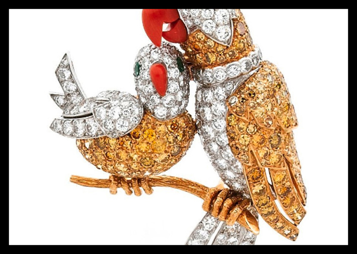Una clip in oro con smeraldi (gli occhi degli uccelli), smalto, platino, corallo (i becchi), diamanti, firmato Cartier