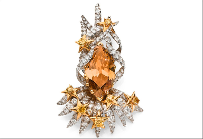 La clip è sostenuta da una corona in platino con diamanti taglio brillante, stelle in oro giallo 18k e diamanti