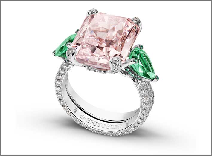 Anello in oro bianco con diamante rosa taglio smeraldo, con due smeraldi a lato