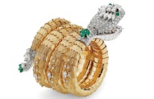 A diamond emerald and gold snake watch bracelet made circa 1967 reveals a circular watch in the mouth with a diamond set bezel.