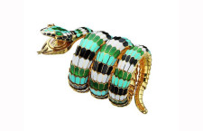 A 1967 Serpenti snake bracelet watch is gold with polychrome enamel and emeralds