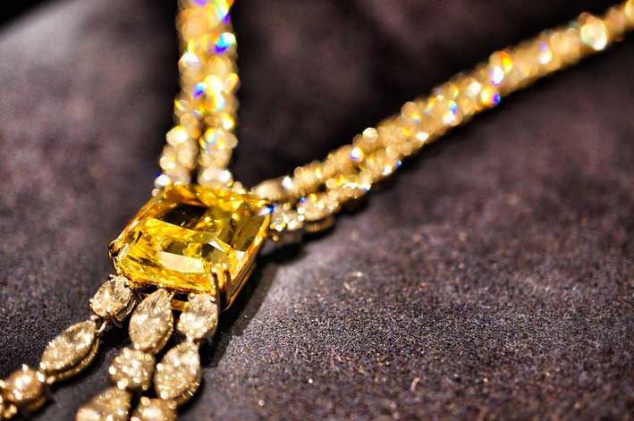 Un particolare di collana con grande pietra gialla e diamanti