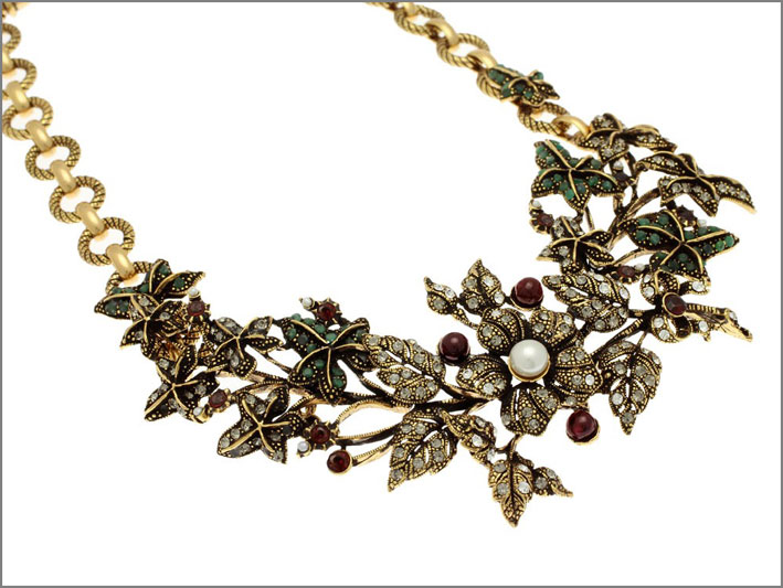 Collier semi-rigido in ottone dorato con ramo e foglie di edera di smeraldo, impreziosite da bacche di granato e fiori di Swarovski dai centrali di perle. Prezzo: 692 euro