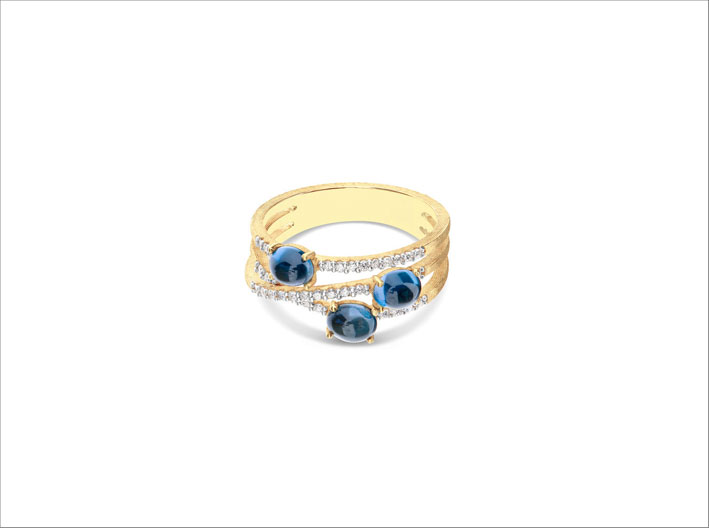 Anello in oro giallo 18 carati, topazio blue London e diamanti bianchi. L'anello è realizzato a mano con la tecnica del bulino millerighe