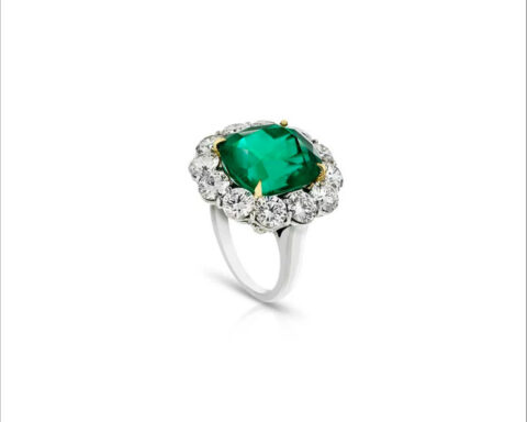 Couchon colombian emerald surrounded by round diamonds