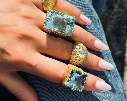 Anello con zaffiro, 1969, della collezione di gioielli e orologi About Time di Andrew Grima per Omega. Uno zaffiro blu fiordaliso circondato da diamanti in platino su strati di oro giallo testurizzato anelli indssati