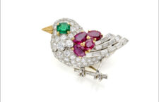 Spilla Cartier a forma di passerotto, in platino e oro con rubini, diamanti e uno smeraldo ottagonale